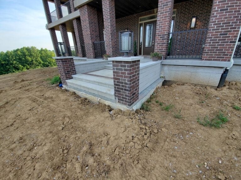 Custom stone front steps with brick pillars in Cedar Rapids, IA, designed for a stylish and durable entryway. Expert hardscape installation enhances curb appeal and complements the home's architecture.